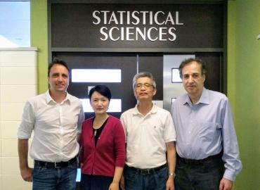 Department faculty members posing under Statistical Sciences sign
